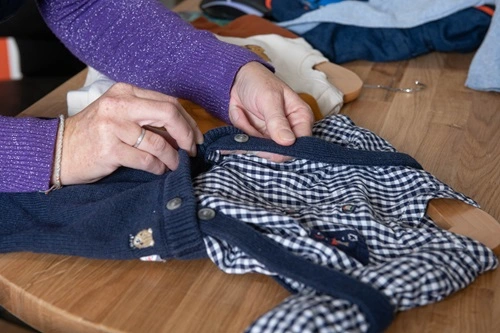 image de l'intérieur de la boutique , Gwenoline controlle un vêtement, plan serré